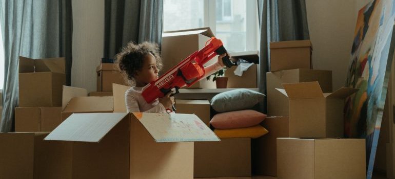 Girl playing in empty moving boxes