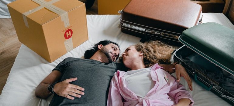 Couple lying on a bed after moving with the help of movers Elkton MD.