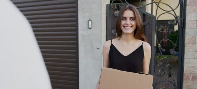 A woman holding a moving box.