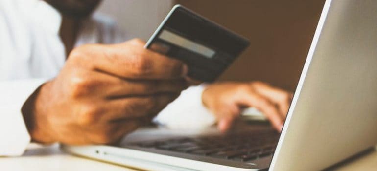 Man using his bank card to shop online on his laptop