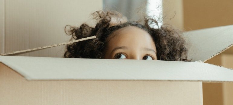 a child peeking from inside the box
