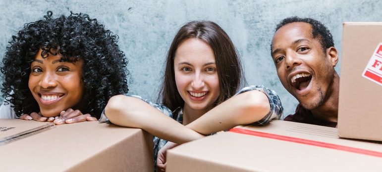 three people surrounded by boxes